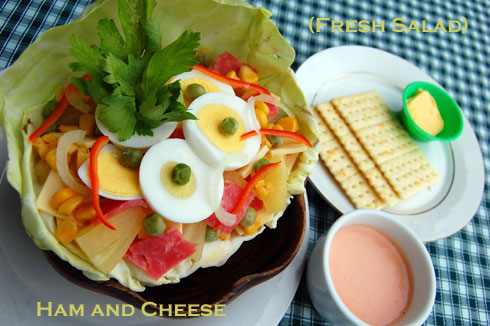 Ham and cheese salad with sliced boiled egg and pineapple slice